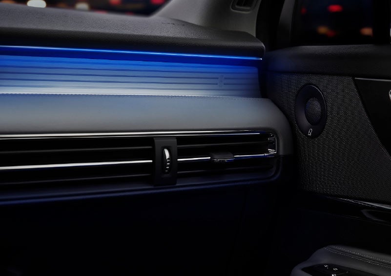 A thin available ambient lighting blue light illuminates the pinstripe aluminum under an ebony dashboard emitting a cool energy