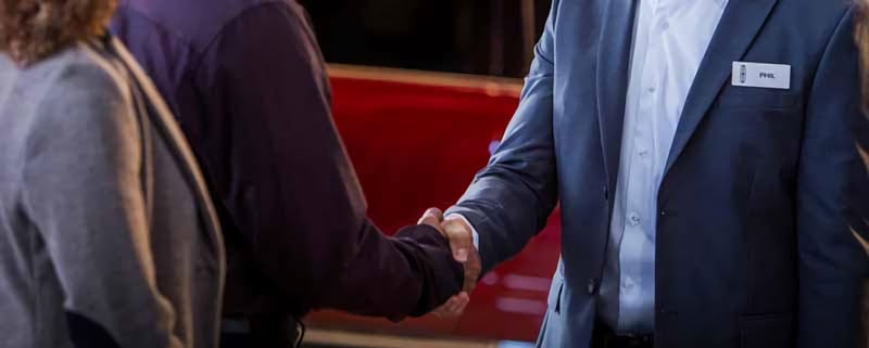 Two people shaking hands at a Lincoln dealership