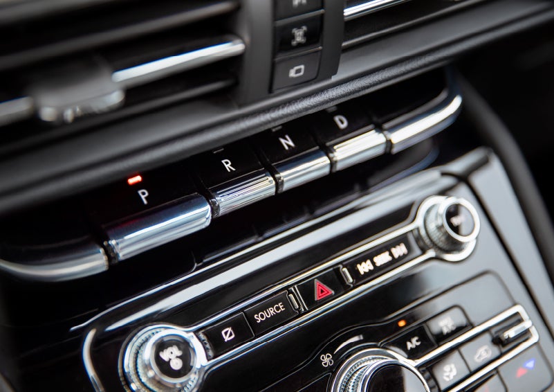 The Park button on the elegant Piano Key Shifter is lit up and engaged as light dances off the chrome accents and horizontal design lines | Covert Lincoln Austin in Austin TX