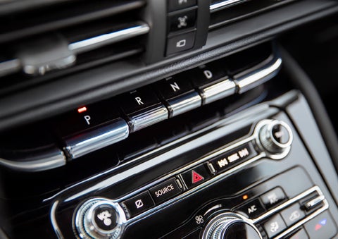 The Park button on the elegant Piano Key Shifter is lit up and engaged as light dances off the chrome accents and horizontal design lines | Covert Lincoln Austin in Austin TX
