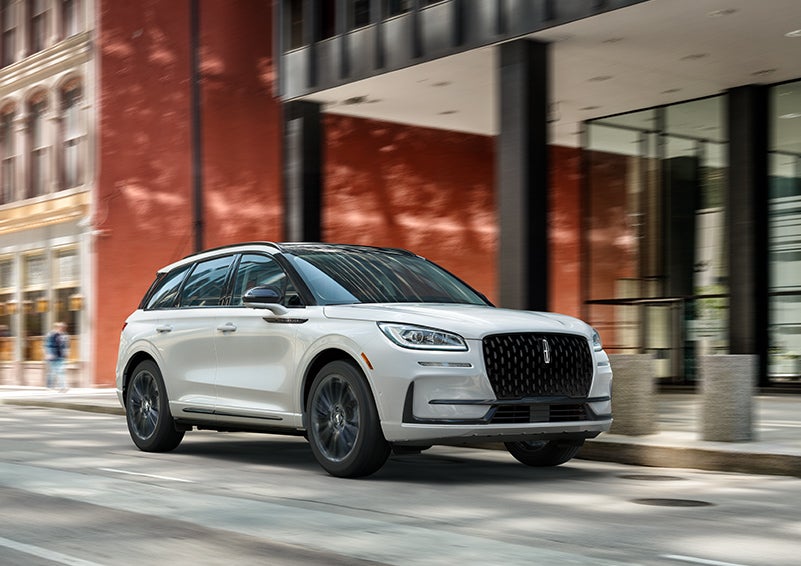 The 2024 Lincoln Corsair® SUV with the Jet Appearance Package and a Pristine White exterior is parked on a city street. | Covert Lincoln Austin in Austin TX