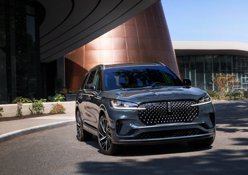 A gray 2025 Lincoln Aviator® SUV is parked outside a modern building with the sun shining. | Covert Lincoln Austin in Austin TX