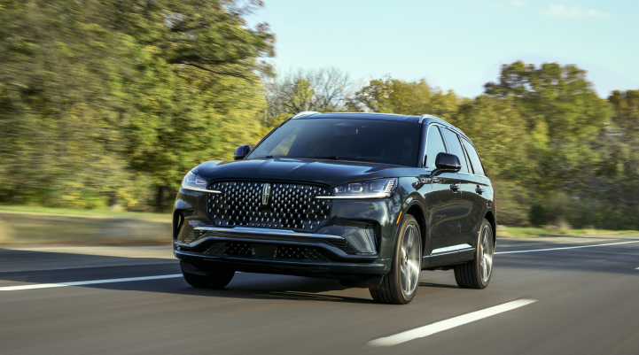 A 2025 Lincoln Black Label Aviator® SUV is being driven down a road lined with trees. | Covert Lincoln Austin in Austin TX