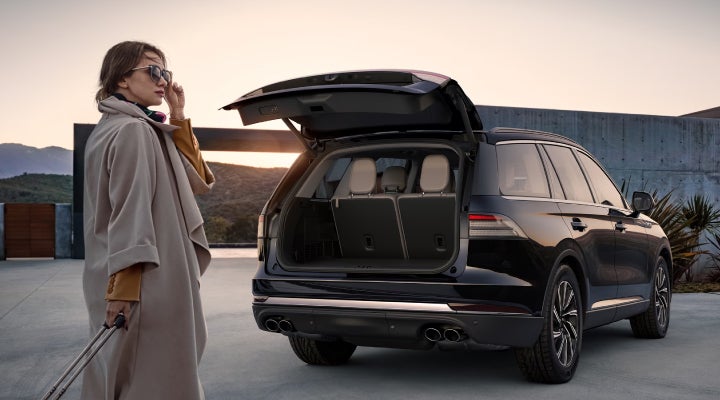 A woman approaches a 2026 Lincoln Aviator® SUV with its rear liftgate open. | Covert Lincoln Austin in Austin TX