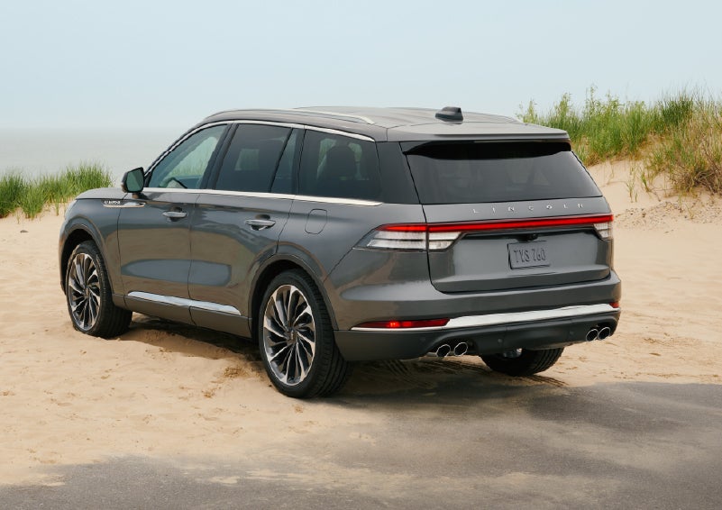 A 2027 Lincoln Aviator® SUV is parked next to sand dunes. | Covert Lincoln Austin in Austin TX
