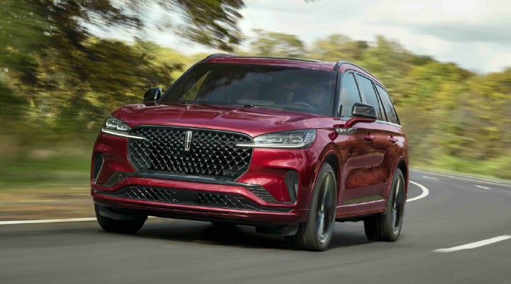 A 2027 Lincoln Aviator® SUV is being driven on a country road | Covert Lincoln Austin in Austin TX