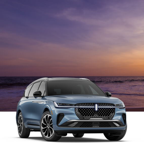 Front three-quarter view of a blue Lincoln Nautilus Reserve with a beach sunset backdrop overlay.
